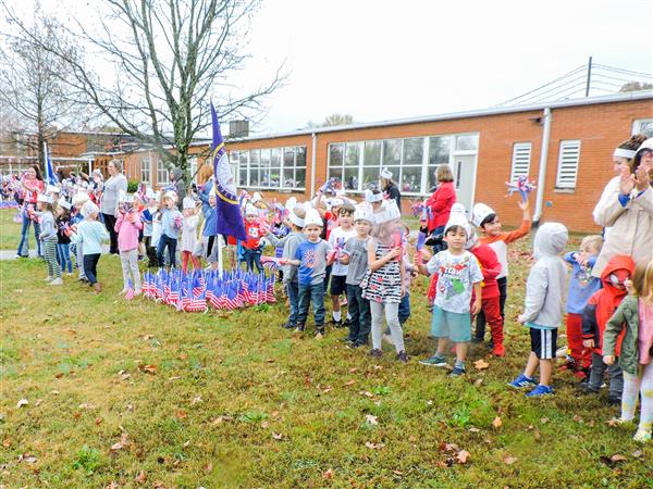 Students holding up homemade signs for a Veterans Day celebration.